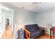 Cozy bedroom featuring a futon, ceiling fan, and hardwood flooring at 9790 Parkwood Ct, Seminole, FL 33777