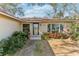 Inviting front entrance with a well-maintained walkway, beautiful plants and a stone accent wall at 9790 Parkwood Ct, Seminole, FL 33777