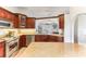 Well-lit kitchen with stainless steel appliances, custom wood cabinets and stone countertops at 9790 Parkwood Ct, Seminole, FL 33777