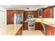 Gourmet kitchen featuring stainless steel appliances and custom wood cabinets at 9790 Parkwood Ct, Seminole, FL 33777