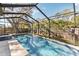 The beautiful pool is enclosed in a screen, and is surrounded by mature landscaping and trees at 9790 Parkwood Ct, Seminole, FL 33777