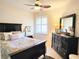 Bedroom with neutral colors, decorative pillows, and a dark wood dresser at 13892 Alafaya St, Venice, FL 34293