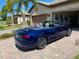 A blue convertible parked in front of a house with a brick driveway and well-maintained landscaping at 13892 Alafaya St, Venice, FL 34293