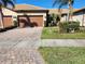 Well-maintained house with a three car garage, manicured lawn, and mature trees at 13892 Alafaya St, Venice, FL 34293