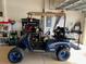 Custom blue and black E-Z-GO golf cart with off road tires inside a garage at 13892 Alafaya St, Venice, FL 34293