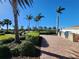 Outdoor grilling area with brick pavers, stone counter, palm trees and landscaping in a lovely outdoor setting at 13892 Alafaya St, Venice, FL 34293