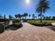 Paver path leads to a gazebo and seating area surrounded by lush landscaping and palm trees at 13892 Alafaya St, Venice, FL 34293