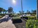 Beautiful outdoor area with lush landscaping, seating, lake view, and a brick walkway at 13892 Alafaya St, Venice, FL 34293