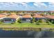 An aerial view of homes with screened in pools overlooking a peaceful lake at 10181 Colubrina Dr, Venice, FL 34293