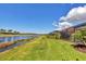 A beautiful backyard features a pool with screened enclosure, lush grass, and a tranquil lake view at 10181 Colubrina Dr, Venice, FL 34293