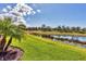 Lush green backyard with pond in the background at 10181 Colubrina Dr, Venice, FL 34293