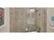 Bathroom with tiled shower, glass enclosure, and toiletries on a floating shelf at 10181 Colubrina Dr, Venice, FL 34293