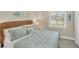 Bright bedroom featuring coastal decor, a wicker headboard, and a window with natural light at 10181 Colubrina Dr, Venice, FL 34293