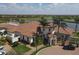 Aerial view of a clubhouse featuring a tile roof, lush landscaping and palm trees at 10181 Colubrina Dr, Venice, FL 34293