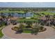 Sarasota National entrance with lush landscaping, a brick roundabout, and a water view at 10181 Colubrina Dr, Venice, FL 34293