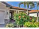 Close up view of a front entrance with a large hibiscus bush and stone details at 10181 Colubrina Dr, Venice, FL 34293
