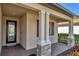 Front porch with stone pillars and an elegant front door with sidelight window at 10181 Colubrina Dr, Venice, FL 34293