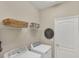 Laundry room with front load washer and dryer and baskets on wire shelving at 10181 Colubrina Dr, Venice, FL 34293