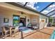 Covered brick patio with ceiling fan, outdoor seating, and view of swimming pool at 10181 Colubrina Dr, Venice, FL 34293