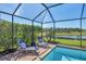 Serene screened-in pool area with lounge chairs and tranquil lake views at 10181 Colubrina Dr, Venice, FL 34293