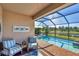 Enclosed pool area featuring brick pool deck, lake views, and comfortable patio seating at 10181 Colubrina Dr, Venice, FL 34293