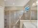 Sleek shower with elegant tile work and integrated shelving, illuminated by natural light at 10181 Colubrina Dr, Venice, FL 34293