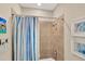 Shower with tiled walls and a glass door, complemented by framed artwork at 10181 Colubrina Dr, Venice, FL 34293