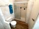 Neutral bathroom featuring wood-look flooring, a shower with glass doors, and a white toilet at 105 Lakeview Dr, North Port, FL 34287