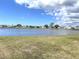 Waterfront community featuring serene lake views, lush lawns, and charming manufactured homes under a bright, cloudy sky at 105 Lakeview Dr, North Port, FL 34287