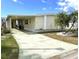 Charming single Gathering home featuring a welcoming front yard, palm trees, and covered parking at 105 Lakeview Dr, North Port, FL 34287