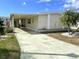 Charming single Gathering home featuring a welcoming front yard, palm trees, and covered parking at 105 Lakeview Dr, North Port, FL 34287