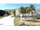 Charming single Gathering home featuring a welcoming front yard, palm trees, and covered parking at 105 Lakeview Dr, North Port, FL 34287