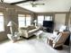 Bright living room with a cream sofa, glass coffee table, and large windows at 105 Lakeview Dr, North Port, FL 34287
