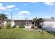 Charming single-story home with a screened-in porch, lush lawn, and tropical palm trees at 1160 Linden Rd, Venice, FL 34293