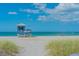 Scenic beachfront view featuring a lifeguard station along a sandy shoreline with grassy dunes and ocean views at 11666 Parrotfish St, Venice, FL 34292