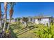Well-maintained backyard with lush landscaping, featuring palm trees and a white fence at 1181 Southland Rd, Venice, FL 34293