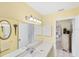 Well-lit bathroom featuring a double sink vanity with a large mirror reflecting the entrance into the home at 1181 Southland Rd, Venice, FL 34293