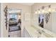 A charming bathroom vanity with a large mirror reflecting a view into an adjacent bedroom at 1181 Southland Rd, Venice, FL 34293