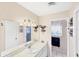 Bathroom featuring a single sink vanity with a white cabinet, a decorative mirror, and a view into the shower room at 1181 Southland Rd, Venice, FL 34293