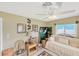 Bedroom featuring a daybed, ceiling fan, and decorative wall art, complemented by two windows and wicker furniture at 1181 Southland Rd, Venice, FL 34293
