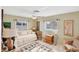 Cozy bedroom featuring a daybed with decorative pillows, a ceiling fan, and two windows with sheer curtains at 1181 Southland Rd, Venice, FL 34293