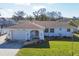 Charming single-story home with a manicured lawn, an attached garage, and nautical-themed decor at 1181 Southland Rd, Venice, FL 34293
