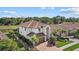 Aerial view of beautiful home with tile roof, tropical landscaping, and brick paver driveway at 12279 Canavese Ln, Venice, FL 34293