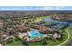 Aerial view featuring a resort-style pool, tennis courts, and lush landscaping surrounding residential buildings at 12279 Canavese Ln, Venice, FL 34293