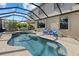 Backyard featuring a screened-in pool and spa, patio, and a view of the home's exterior at 12279 Canavese Ln, Venice, FL 34293