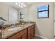 Bathroom featuring granite countertops, double sinks, wood cabinets, and a large mirror at 12279 Canavese Ln, Venice, FL 34293
