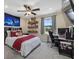 Comfortable bedroom featuring a ceiling fan, a desk, and sports memorabilia decor at 12279 Canavese Ln, Venice, FL 34293
