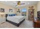 Comfortable bedroom with a ceiling fan, large window, and decorative shelving unit at 12279 Canavese Ln, Venice, FL 34293