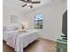 Bright bedroom featuring tile floors, tray with flowers on bed, and a large window at 12279 Canavese Ln, Venice, FL 34293