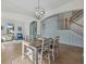 Charming dining room with a modern light fixture, stylish furnishings, and staircase access at 12279 Canavese Ln, Venice, FL 34293